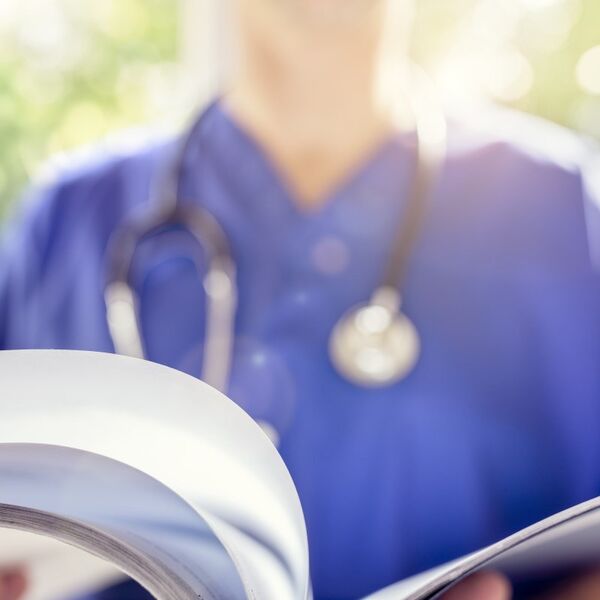 Nurse with stethoscope reading a document